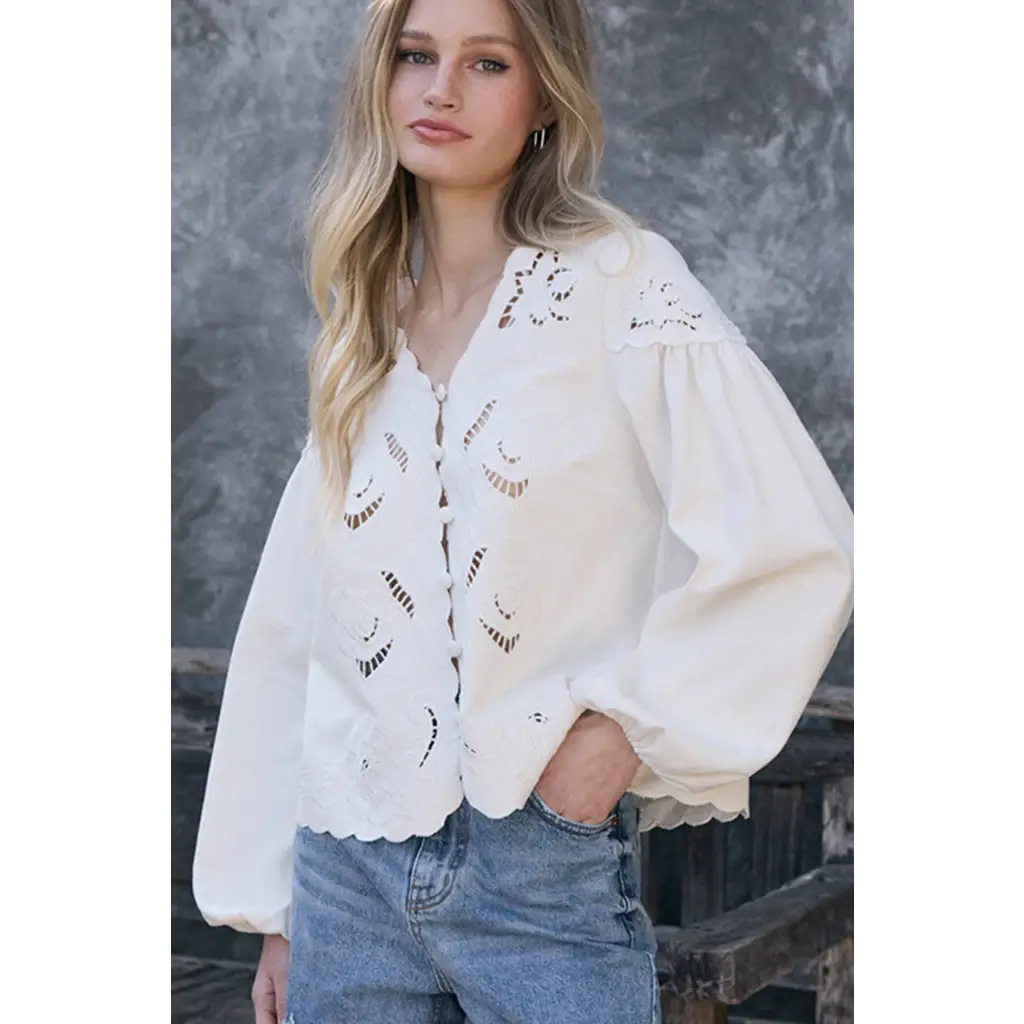 White eyelet blouse with floral cutout embroidery, puffed sleeves, scalloped hem