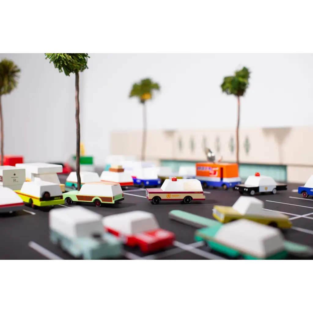 Miniature toy cars in a model parking lot with a Vintage Wooden Sheriff Truck Toy