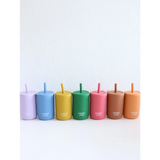 Seven colorful mini silicone straw cups for kids in a rainbow arrangement