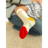 Red and white Silly Goose toddler socks with green text on gray background