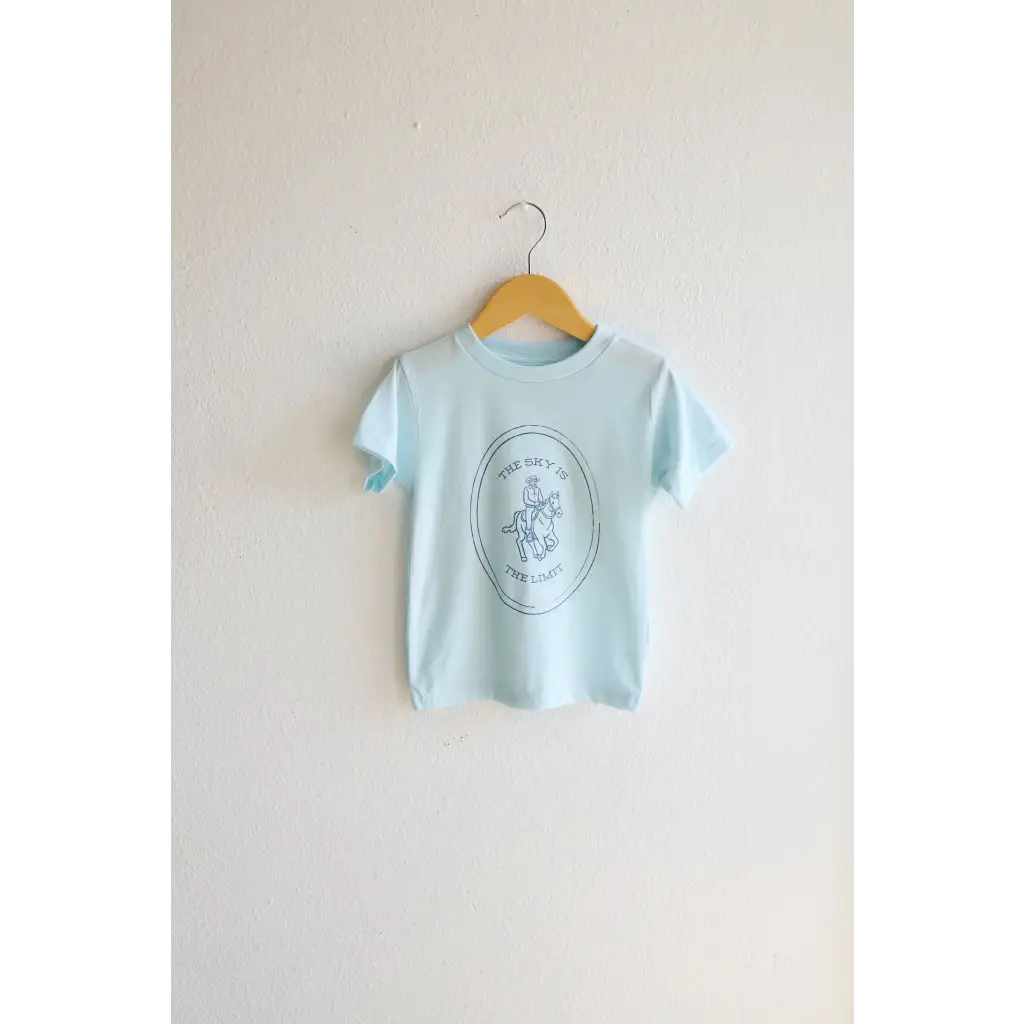 Light blue softest graphic t-shirt with horse and rider design on wooden hanger