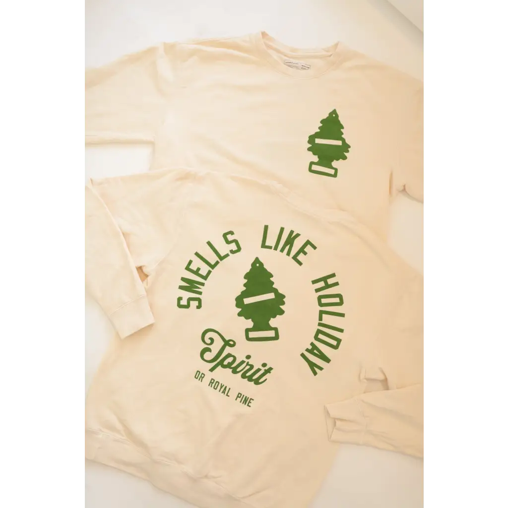 Cream-colored lightweight pullover with green ’Smells Like Holiday Spirit’ text and pine trees