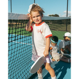 Young tennis player in Soft Girls Club Ringer Tee with red trim on the court