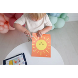 Orange paper with a smiling sun drawing for Space Scissor Skills Activity Kit