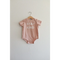 Cute pink baby onesie in organic cotton fabric features Stay Kind slogan for little ones