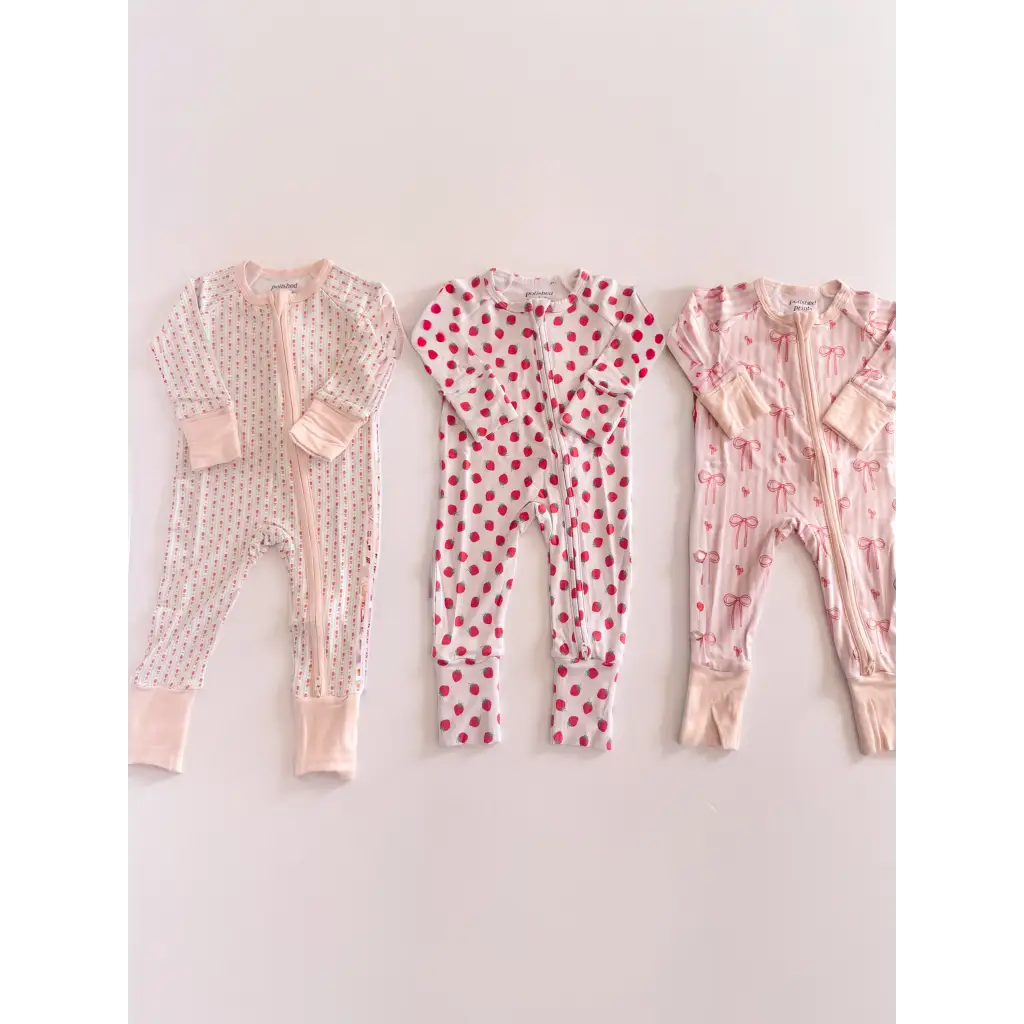 Three pink bamboo baby sleepers with dot and bow prints