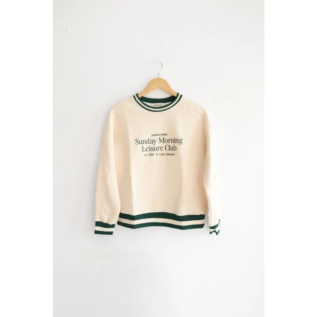 Cream sweatshirt with green trim featuring Sunday Morning Leisure Club design