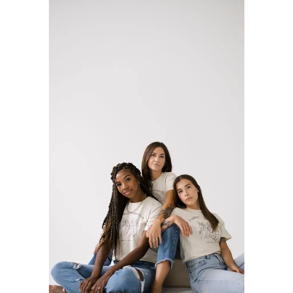 Three friends in white tees and jeans showcasing the Support Sisterhood Relaxed Tee