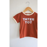 Rust t-shirt for tot kids with TATER TOT print and cream trim on a wooden hanger