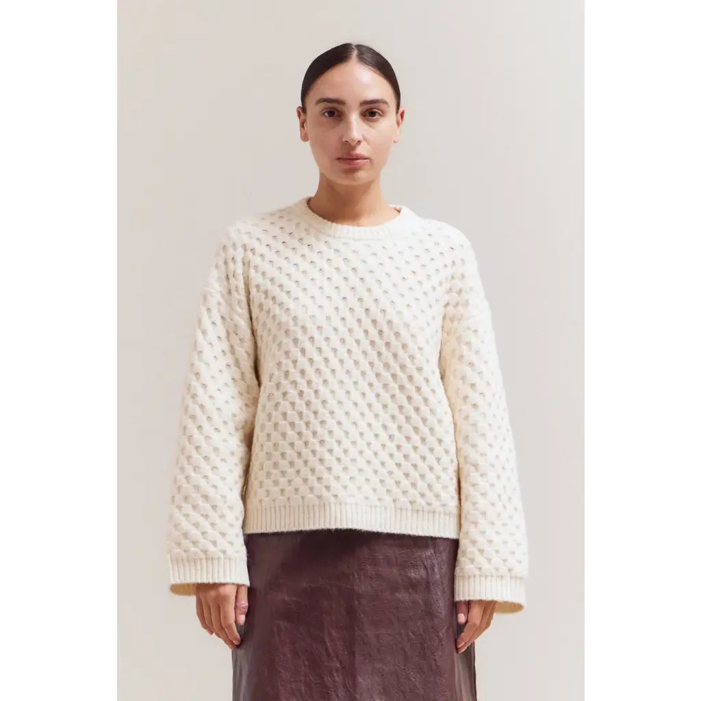 Cream-colored Betsy Crew Knit sweater with textured pattern and ribbed cuffs
