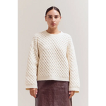 Cream-colored Betsy Crew Knit sweater with textured pattern and ribbed cuffs