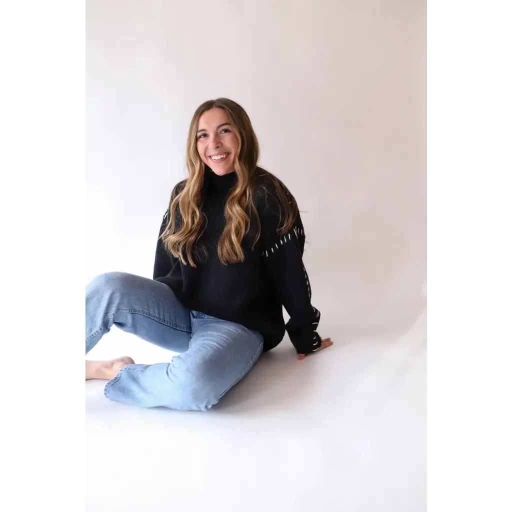 Person in a black turtleneck and light blue jeans showcasing the Brandi Contrast Sweater