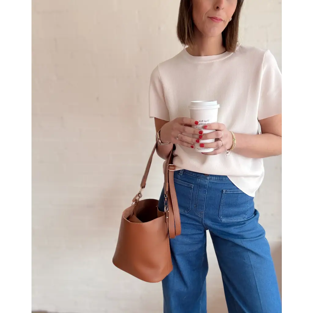 Woman enjoying coffee with The Brooke Everyday Bucket Bag in brown leather