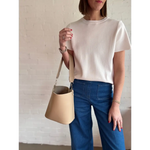 Woman’s outfit styled with The Brooke everyday bucket bag in beige