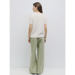 Woman in light t-shirt and wide-leg green pants from stylish womens clothes collection