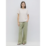 Woman in beige t-shirt and green pants, perfect stylish womens clothes for moms