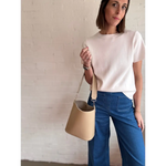 Woman rocking a beige bucket bag with The Deanna short-sleeve knit tee