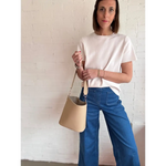 Woman styling a beige bucket bag with The Deanna Top short-sleeve knit tee