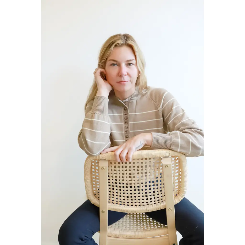 Cane-backed wooden chair with a rattan seat complements the Ellen Henley sweater in classic style