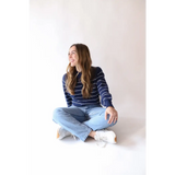 Navy and white striped sweater paired with light blue jeans and sneakers, perfect for Peace Signs Camp