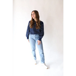 Person in The Ellen Henley Sweater in Navy with peace signs camp vibe and light blue jeans