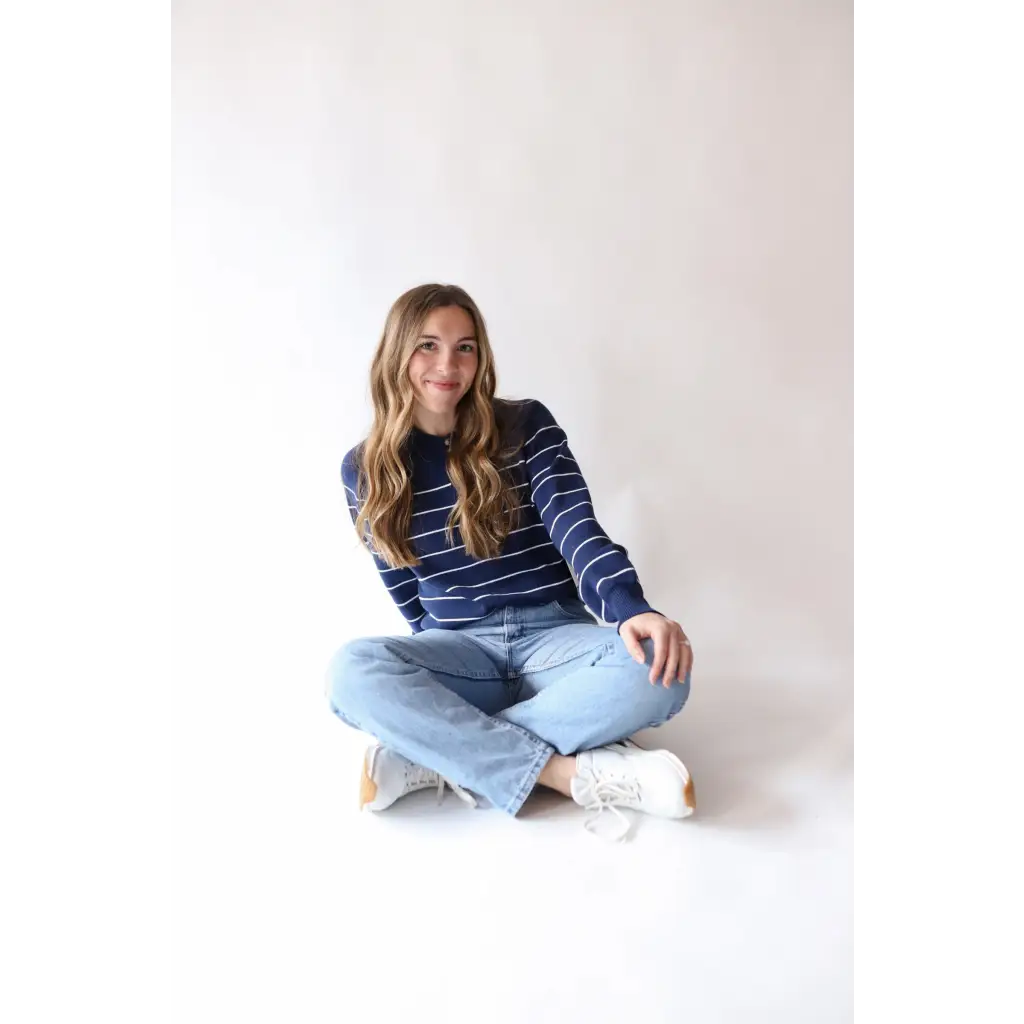 Person in Navy Ellen Henley Sweater and light blue jeans with three peace signs