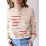 Cream-colored striped sweater with red lines and buttons, perfect for peace signs camp vibes