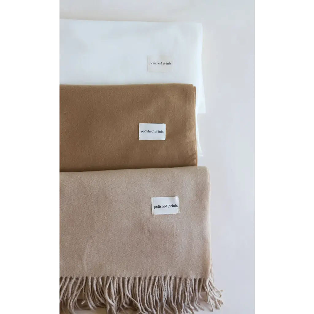 Neutral-toned essential wool blend scarves with fringe tassels stacked together