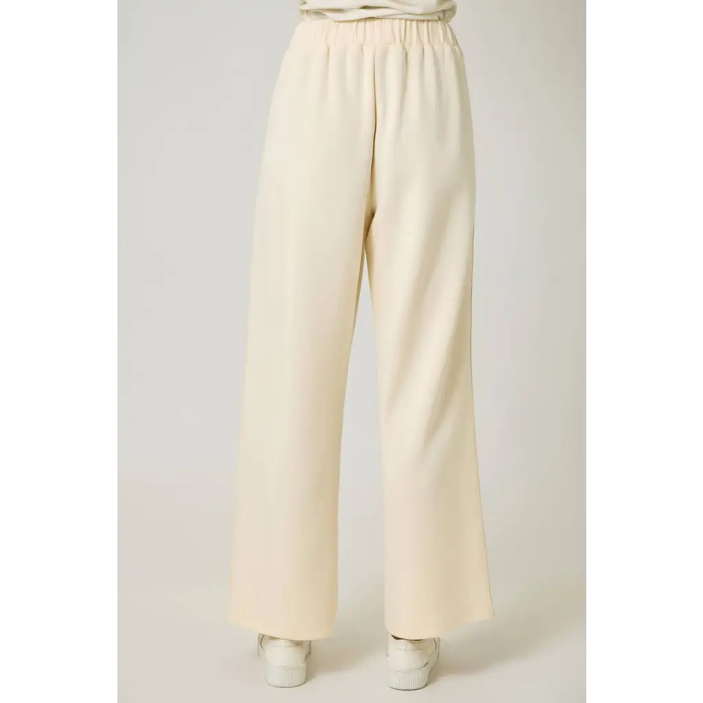 Cream-colored tracksuit pants with elastic waistband and rust stripes, perfect for casual wear