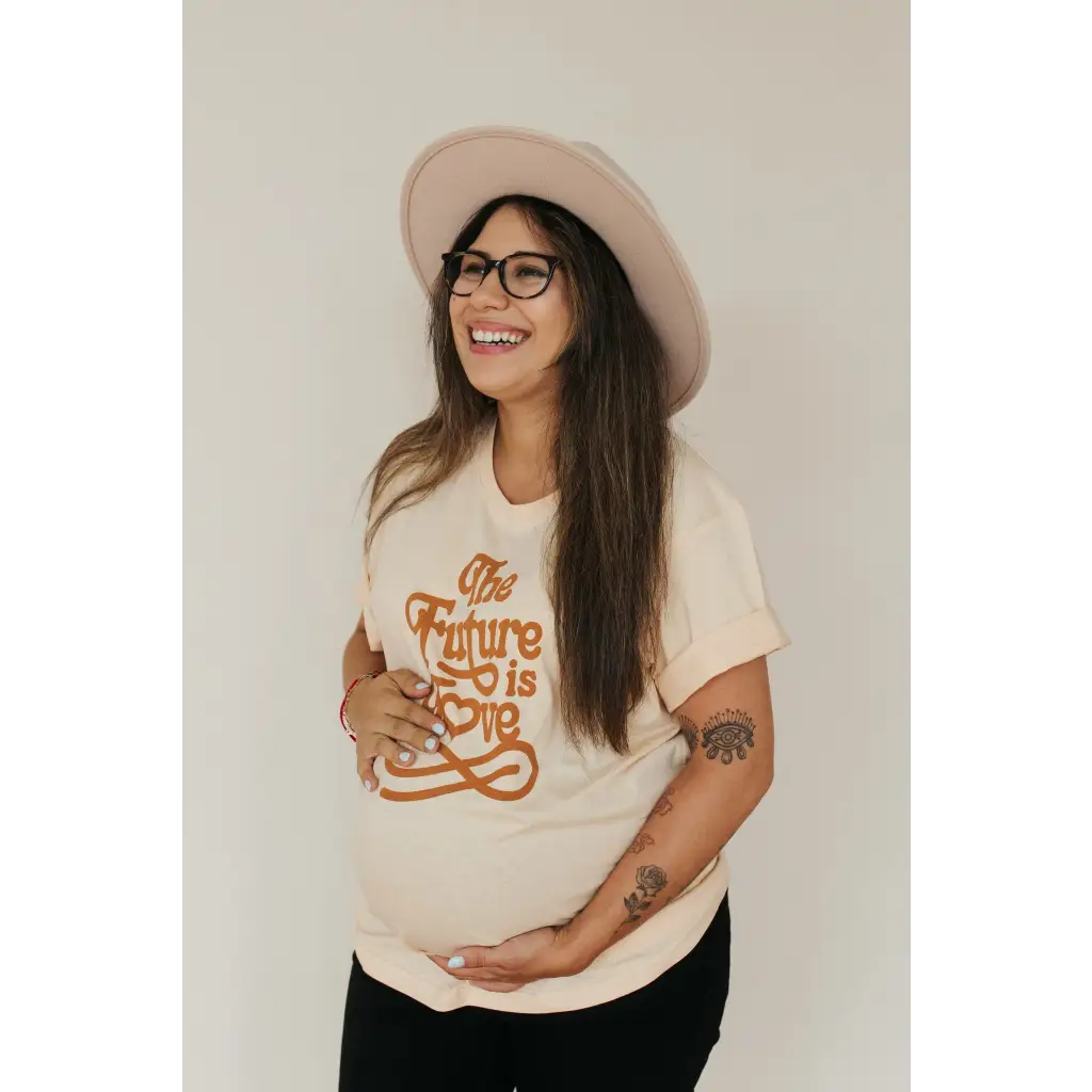 Joyful person rocking a Cream Love Graphic T-shirt with polished prints and a pink hat