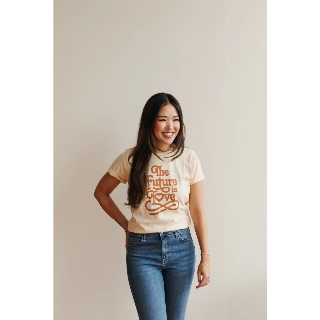 Person rocking a Cream Love Graphic T-shirt with polished prints and blue jeans