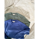 Three cozy Margo Crew Neck Sweaters in beige, sage green, and royal blue laid flat