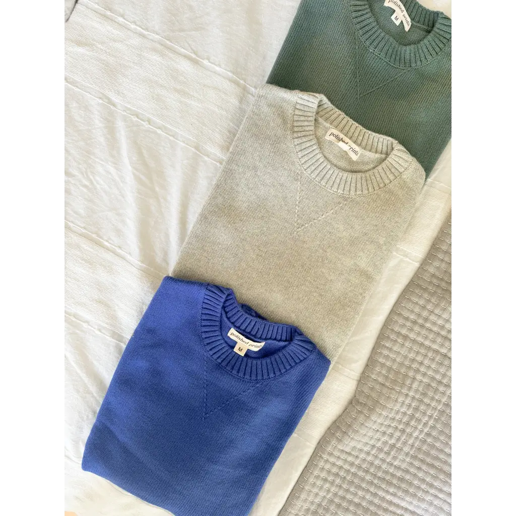 Three Margo Crew Neck Sweaters in blue, beige, and dark green with ribbed details