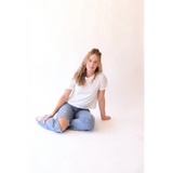Woman in ripped jeans and white T-shirt wearing The Mom Crop boxy tee for a stylish mom look