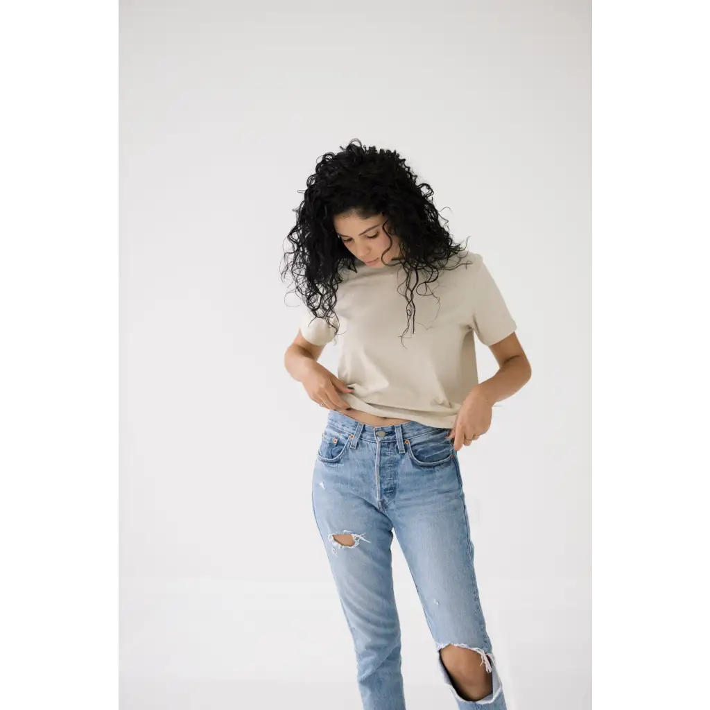 Curly-haired person rocking a Chill in the Mom Crop Tee in Bone White for a polished look