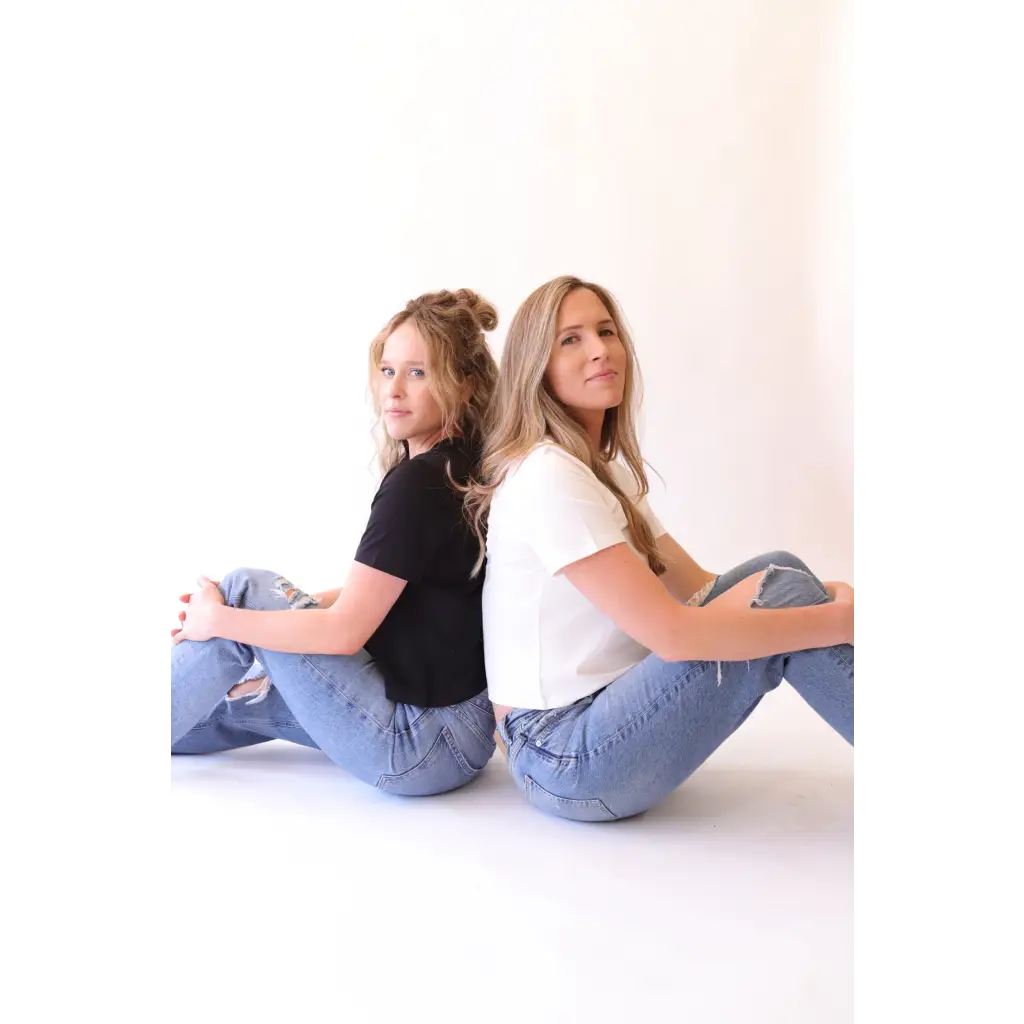 Two women in jeans and T-shirts showing off The Mom Crop boxy tee in Jet Black