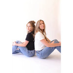 Two women in jeans and T-shirts showing off The Mom Crop boxy tee in Jet Black