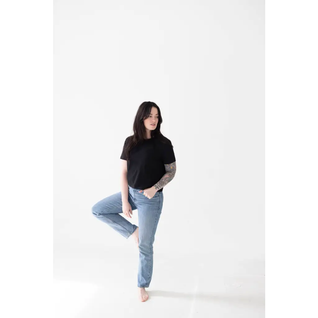 Casual pose in a black mom crop boxy tee and light blue jeans for effortless style