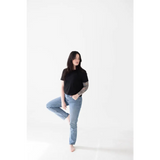 Casual pose in a black mom crop boxy tee and light blue jeans for effortless style