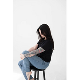 Person with dark hair in a black Stylish Mom Crop Boxy Tee sitting on a stool