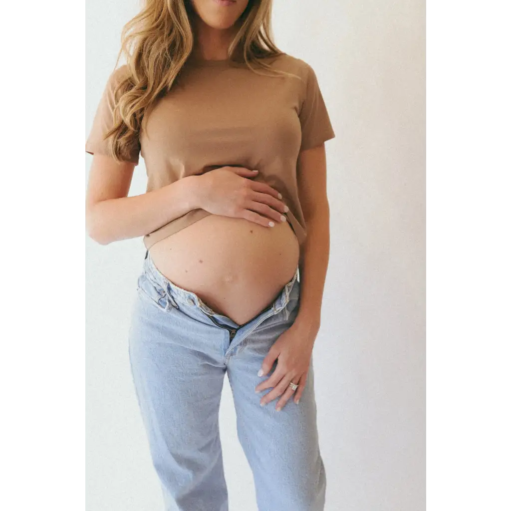 Pregnant woman in The Mom Crop in Mocha, stylish womens clothes with polished prints