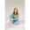 Person in a grey mom crop boxy tee and blue jeans sitting cross-legged on the floor