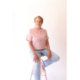 Elderly woman sitting on a pink stool wearing The Mom Crop in Rose with stylish womens clothes