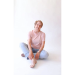 Elderly woman sitting cross-legged in The Mom Crop in Rose with stylish womens clothes
