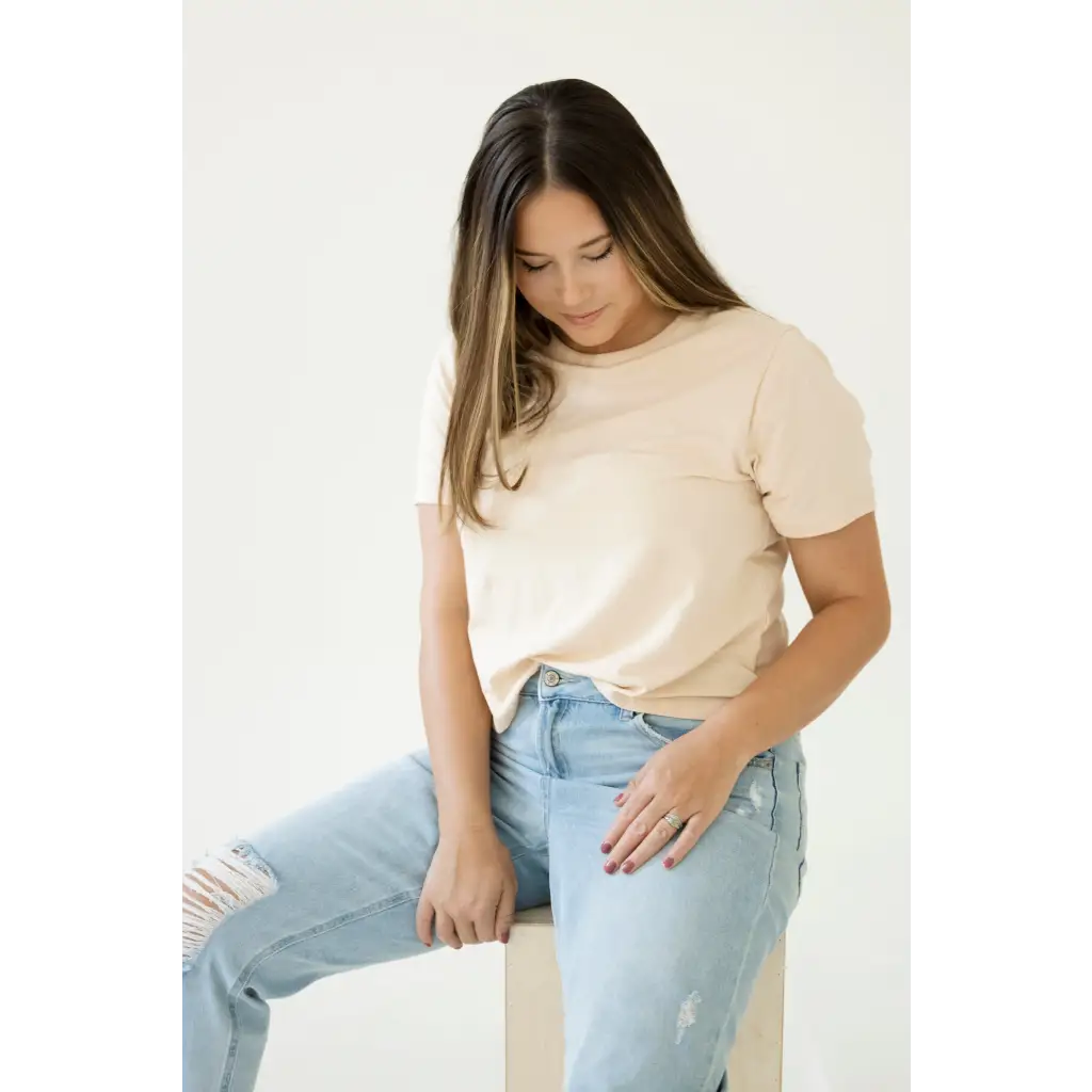 Person in a cream mom crop boxy tee and light blue jeans for casual vibes