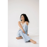 Woman with curly hair in a light blue denim and white mom tank, perfect for any occasion