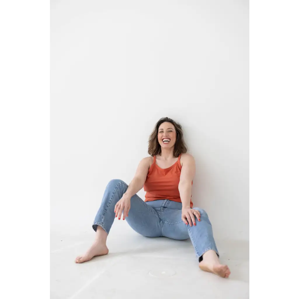 Casual look in a red mom tank and blue jeans, showcasing stylish womens clothes with polished prints