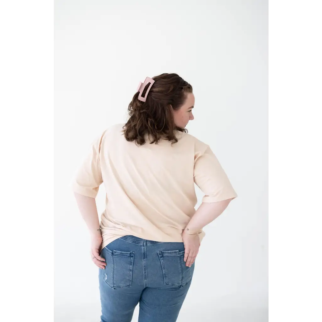 Person in cream Mom Tee made from organic cotton and spandex blend, seen from behind