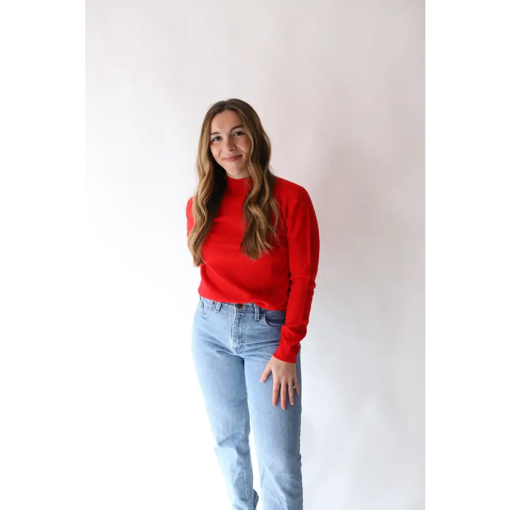 Person rocking the Sherry Sweater in Bright Red with light blue jeans for everyday style