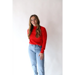 Person rocking the Sherry Sweater in Bright Red with light blue jeans for everyday style